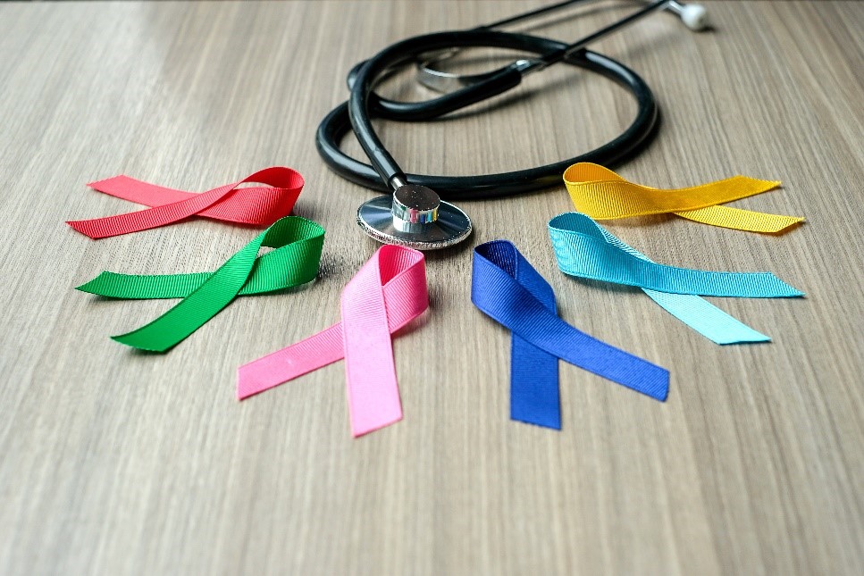 A picture of colorful ribbons and a stethoscope on a wood background.